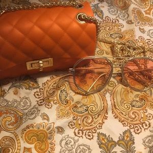 Orange delexury hang purse  a pair of sunglasses